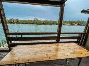 a wooden bench sitting on the side of a river at Mini Tri in Ulcinj