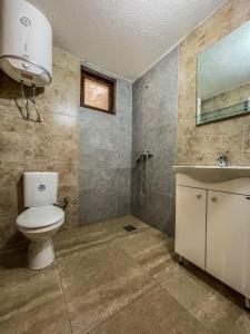 a bathroom with a toilet and a sink and a mirror at Mini Tri in Ulcinj