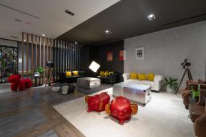 a living room with a couch and red chairs at 凝萃文旅 台中車站店 NCH-Business Hotel in Taichung +37 photos