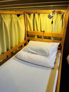 a bed in a room with a yellow curtain at Minsyuku Koshiyama in Shirakawa