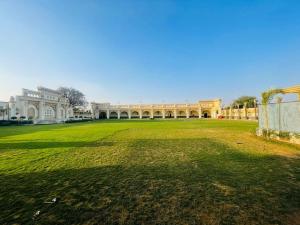 a large building with a large lawn in front of it at Pink Mahal Hotel & Resort in Jaipur