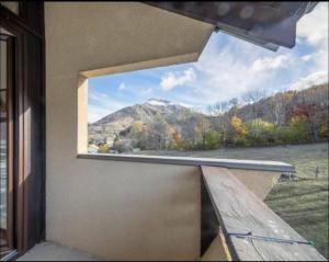 Una ventana en un edificio con vista a una montaña. en Trés jolie duplex à Ancelle, en Ancelle 3 fotos más