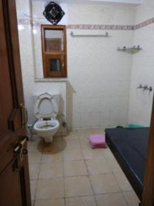 uma casa de banho com um WC, uma janela e uma cama em Goroomgo शिमला Nature Ville - A Luxury Collection em Shimla