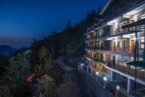 - une vue sur un hôtel la nuit dans l'établissement Goroomgo शिमला Nature Ville - A Luxury Collection, à Shimla