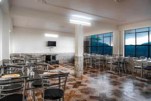 Goroomgo शिमला Nature Ville - A Luxury Collection في شيملا: قاعة اجتماعات مع طاولات وكراسي ومدفأة