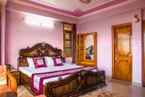 um quarto com uma cama de madeira e paredes cor-de-rosa em Goroomgo शिमला Nature Ville - A Luxury Collection em Shimla