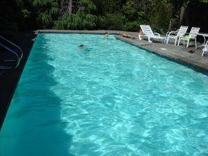 una piscina con 2 personas en el agua en Hilltops, en Surrey