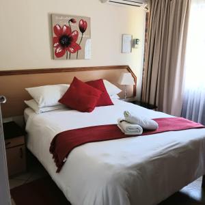 a hotel room with a bed with two towels on it at Flamingo Holiday Flats in St Lucia
