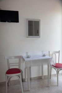 a white table with two chairs and a mirror at Villa Veneti in Néos Pírgos