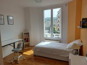 a bedroom with a bed and a desk and a window at Bamboo villa in Meudon