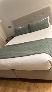 a bed with green sheets and pillows on it at Duplex de lujo junto al Bernabéu Real Madrid in Madrid