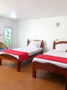 two beds sitting next to each other in a room at Moradok Thai Guesthouse in Phra Nakhon Si Ayutthaya