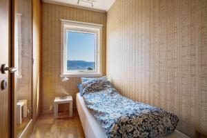 a small bedroom with a bed and a window at Villa Ocean View in Askøy