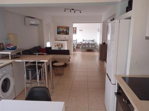 Nicosia rest and relax 1 bedroom apartment في نيقوسيا: مطبخ وغرفة معيشة مع أريكة وطاولة