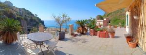 a patio with a table and chairs and the ocean at L'oblò in Riomaggiore