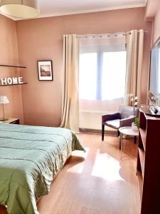 una camera con un letto e una sedia e una finestra di Crystal Clear - 2 separate bedrooms and PARKING a Komotini