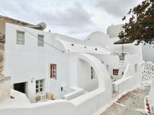a house clad in white with a spiral staircase at as holiday caves in Mesaria