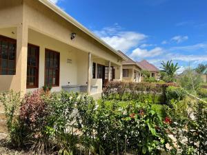 a house with a garden in front of it at Tanzania Safari Lodge in Arusha