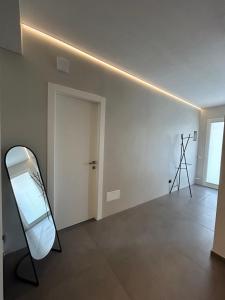 a white room with a mirror and a door at lemaree Torre dell orso Lecce in Torre dell'Orso