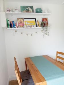 a shelf above a table with books and a chair at Galway Riverside Retreat in Galway +17 photos