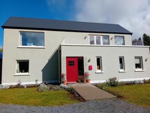 a white house with a red door at Galway Riverside Retreat in Galway