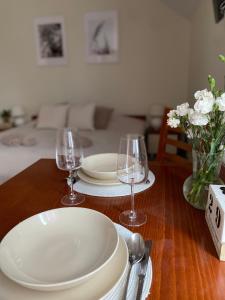 una mesa de madera con dos platos y copas de vino en Willa Polanka en Gościno