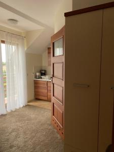 a room with a dresser and a door with a kitchen at Willa Polanka in Gościno