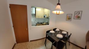 a dining room with a table and chairs and a kitchen at Antillas Fenals Apartment in Lloret de Mar in Lloret de Mar