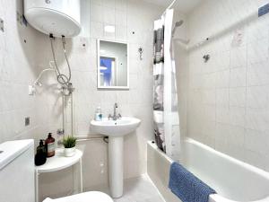 a bathroom with a sink and a toilet and a tub at White studio in Torrevieja