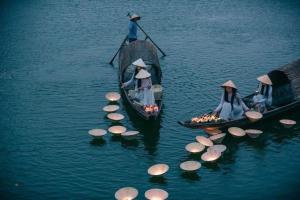 un grupo de personas en barcos con paraguas en el agua en Jade Hotel, en Hue