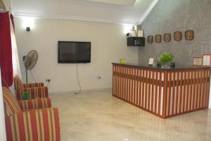 a waiting room with a flat screen tv on the wall at Gold Plus Hotel Ghana in Kumasi