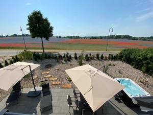 a patio with two umbrellas and a swimming pool at Auszeit Oase Heidi in Göhren-Lebbin