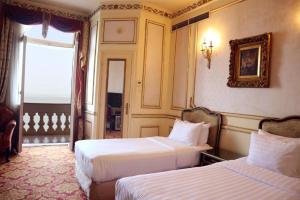 a hotel room with two beds and a window at Windsor Palace Luxury Heritage Hotel Since 1906 by Paradise Inn Group in Alexandria