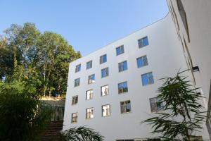 a white building with trees in front of it at Best Western Hotel Spinnerei Linz in Linz