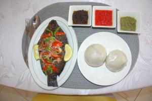 a plate of food on a table with a plate of food at Gold Plus Hotel Ghana in Kumasi