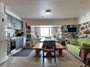 a kitchen and living room with a table and a couch at Lappalaisen lomamökit Majoitushuoneisto in Puumala