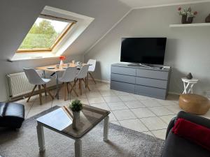 a living room with a flat screen tv and a table at Aminas Ferienwohnung Bad Gandersheim 30/2 in Bad Gandersheim
