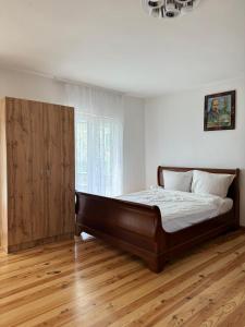 1 dormitorio con 1 cama grande y armario de madera en Прикарпаття en Kosiv