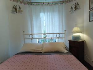 a bed in a bedroom with a window and a lamp at Art Cottage in Pontlevoy