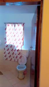 un bagno con servizi igienici e una tenda con gli uccelli di Marion's incredible 1 bedroom apartment a Watamu