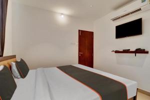 a bedroom with a bed and a tv on the wall at Srinidhi comfort in Bangalore