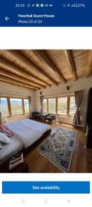 a bedroom with a large bed and a rug at Heschuk Guest House in Leh