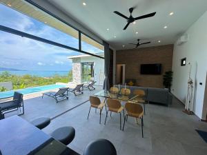 - un salon avec un ventilateur de plafond et une piscine dans l'établissement Baan Saint-Tropez Seaview Villa Ko Samui., à Bophut 