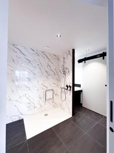 a bathroom with a marble wall at Mr.Bernard Vakantie Appartementen in De Panne