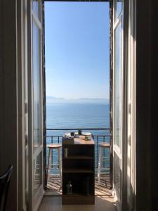Habitación con ventana abierta y vistas al océano. en B&B Vista Mare, en Nápoles