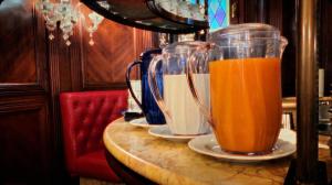 dos jarras de zumo de naranja en platos en una mesa en Hotel Lux, en Venecia