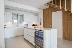 a kitchen with white cabinets and an island with an oven at Moderne Villa mit Pool und Meerblick in Pounda