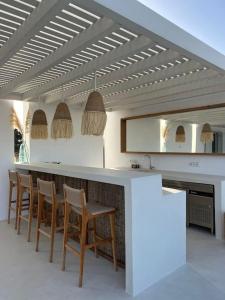 a kitchen with a bar with chairs and a fireplace at Moderne Villa mit Pool und Meerblick in Pounda