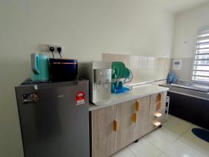 依斯干達的住宿－FIRASH HOMESTAY AT SERI ISKANDAR，厨房配有冰箱和台面