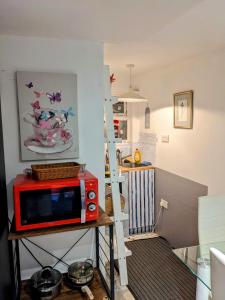 un forno a microonde rosso seduto su un tavolo in cucina di Small apartment in the heart of Selsdon! a Addington